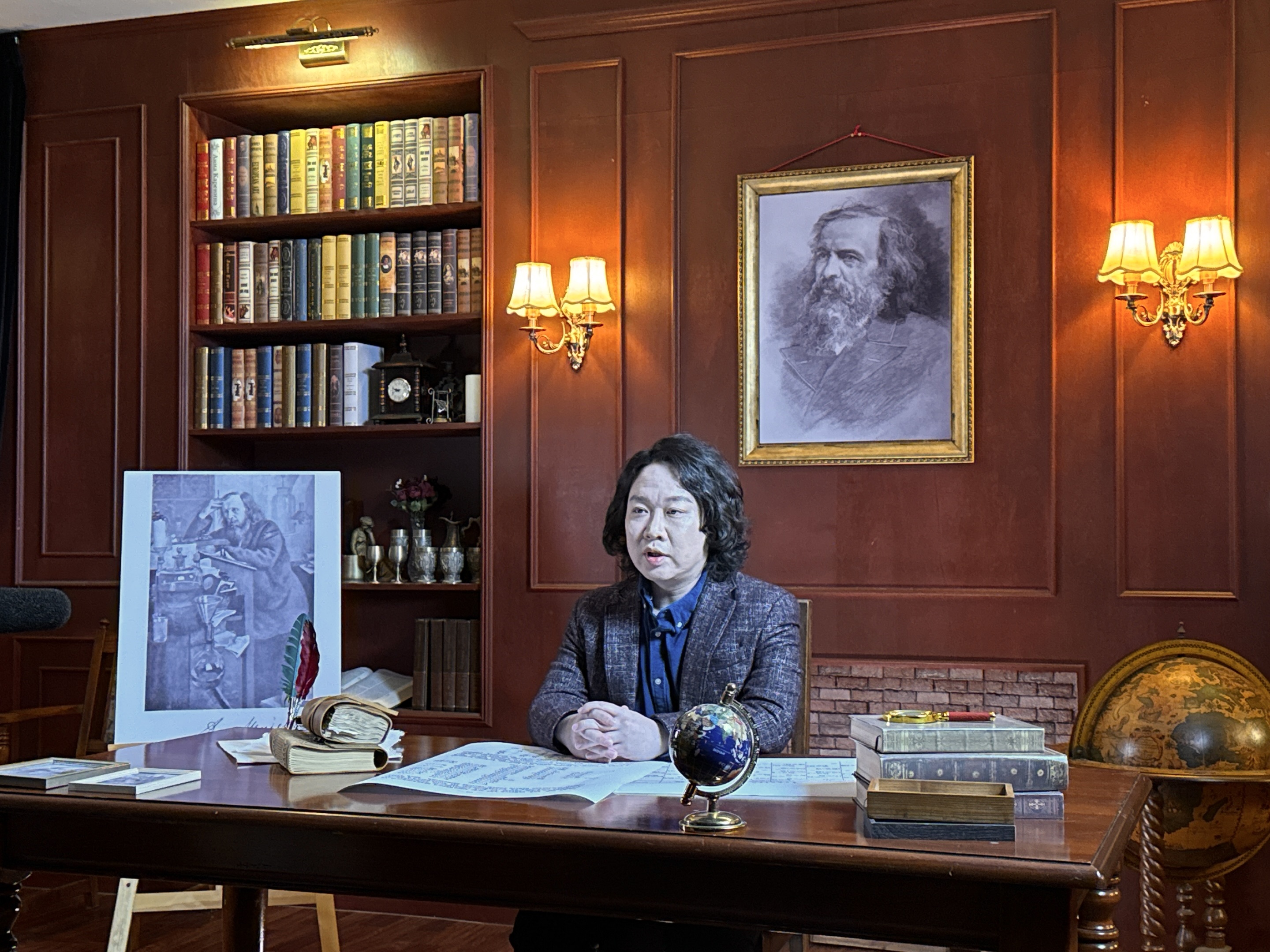 서재 세트의 책상에 앉아 이야기하는 녹화 모습