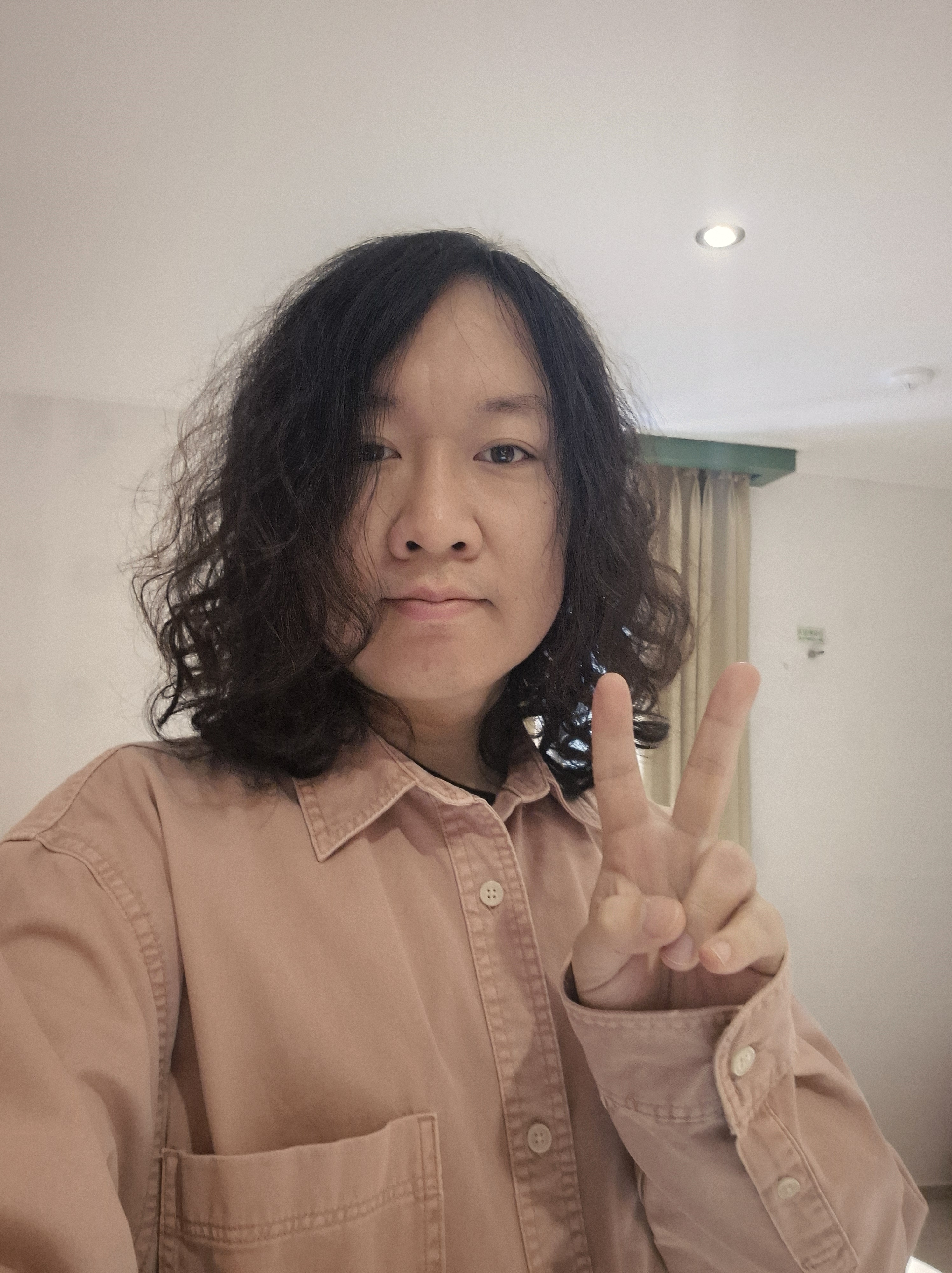 분홍색 셔츠를 입고 브이 포즈로 찍은 셀카