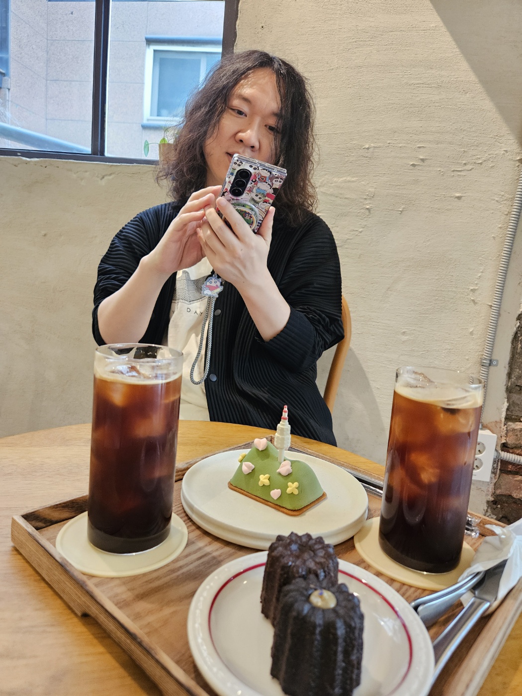 카페에서 휴대전화를 보는 모습